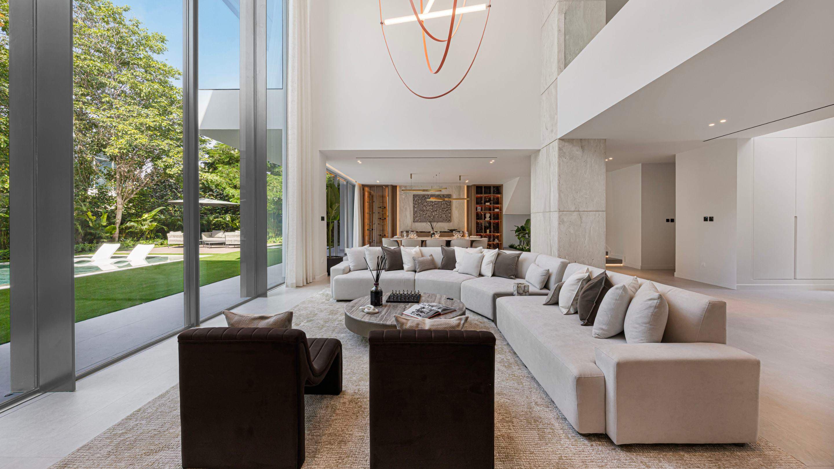 Double-height Al Barari living room opening onto a garden