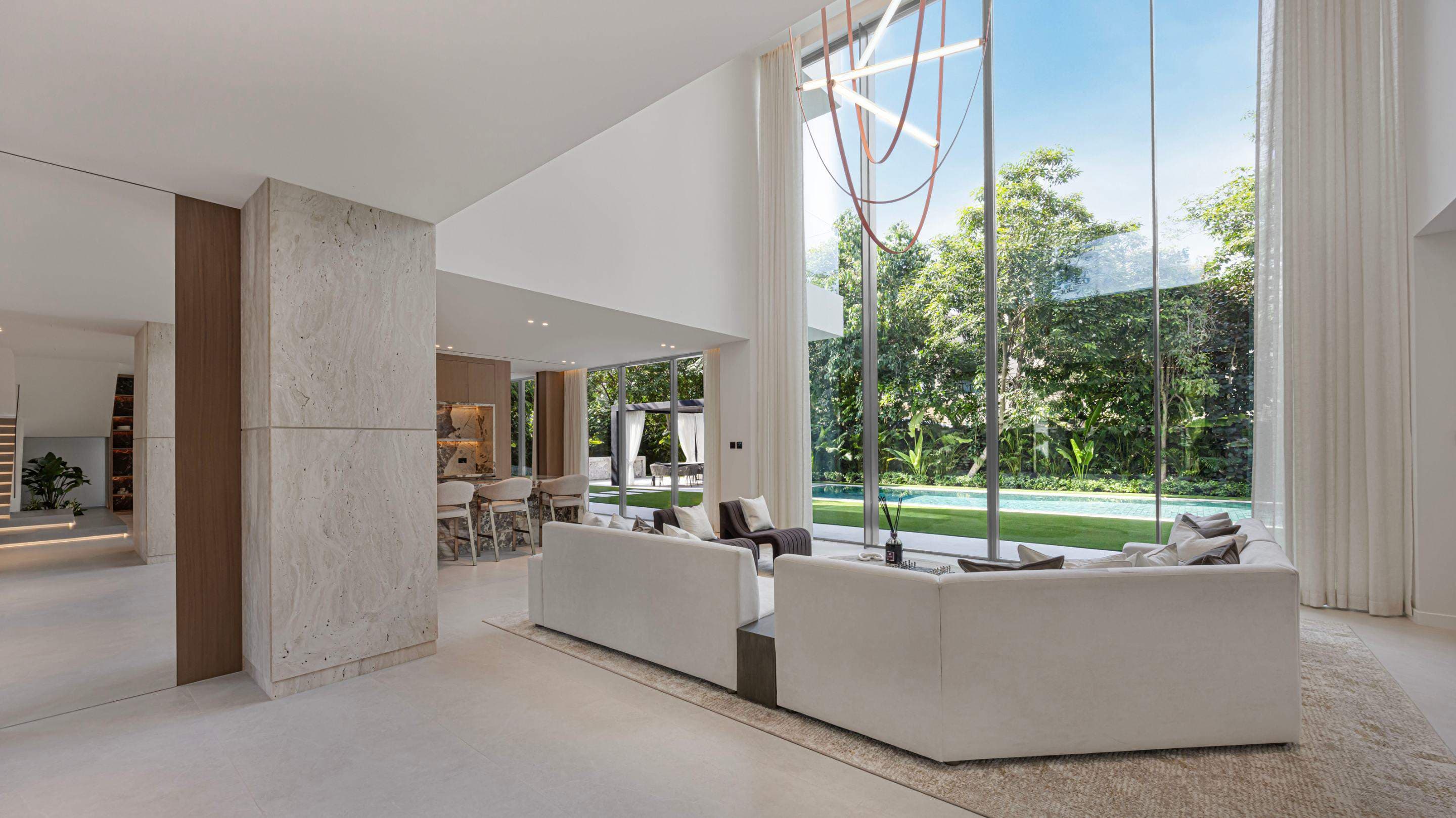 Al Barari villa living room with double-height glazing onto the garden