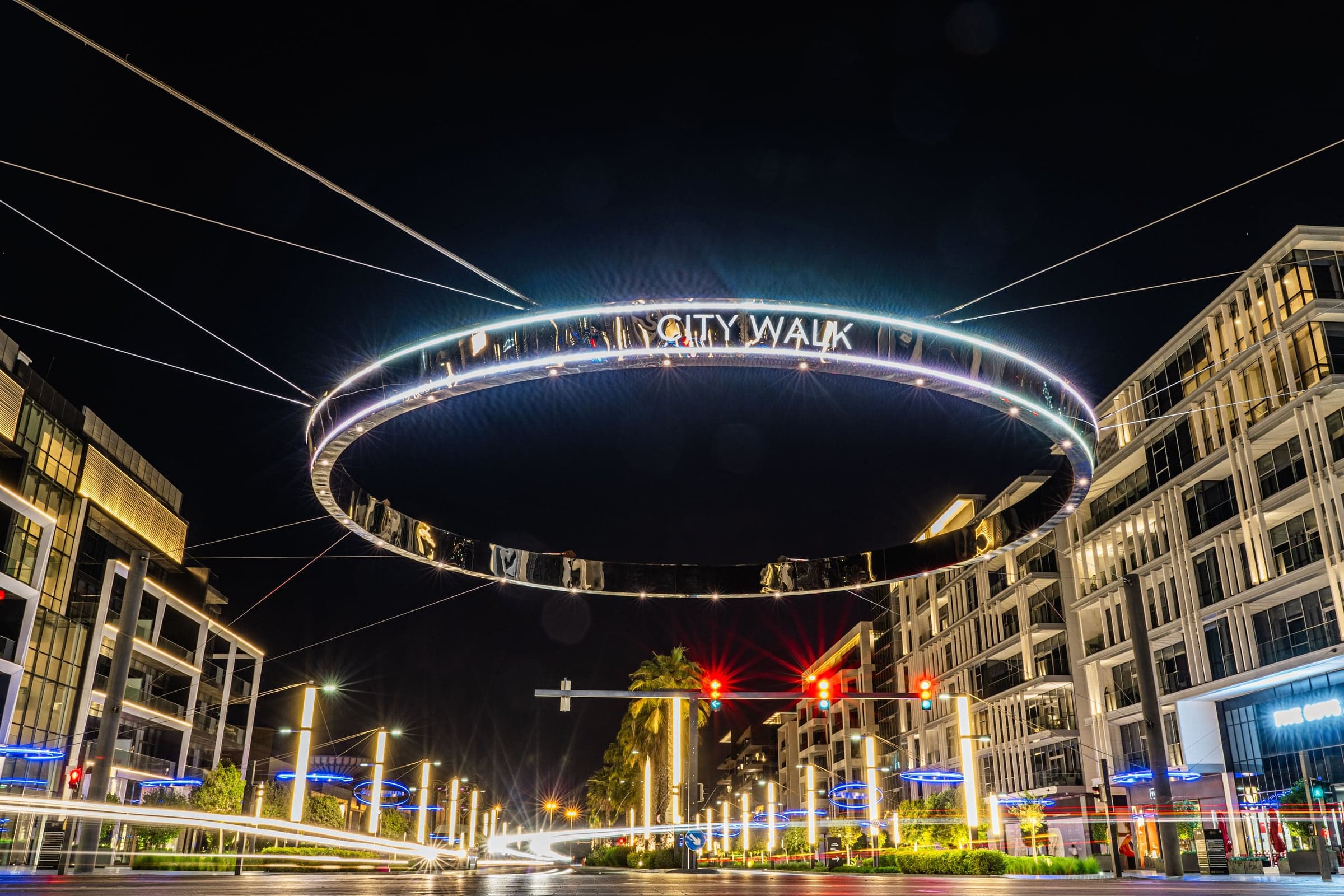 The illuminated City Walk ring sign above the boulevard at night in City Walk, Dubai