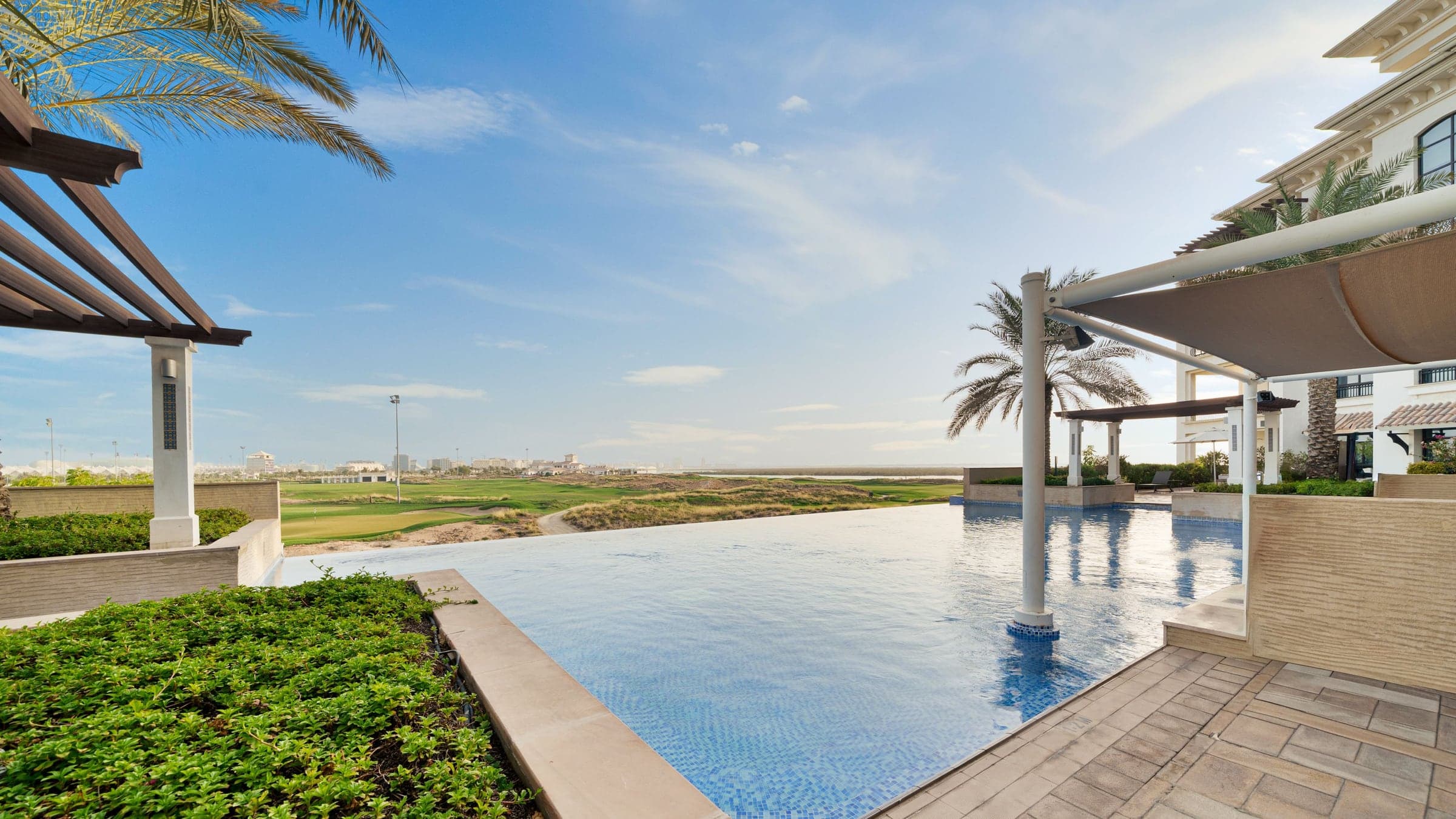 Villa infinity pool overlooking a green golf course in Dubai