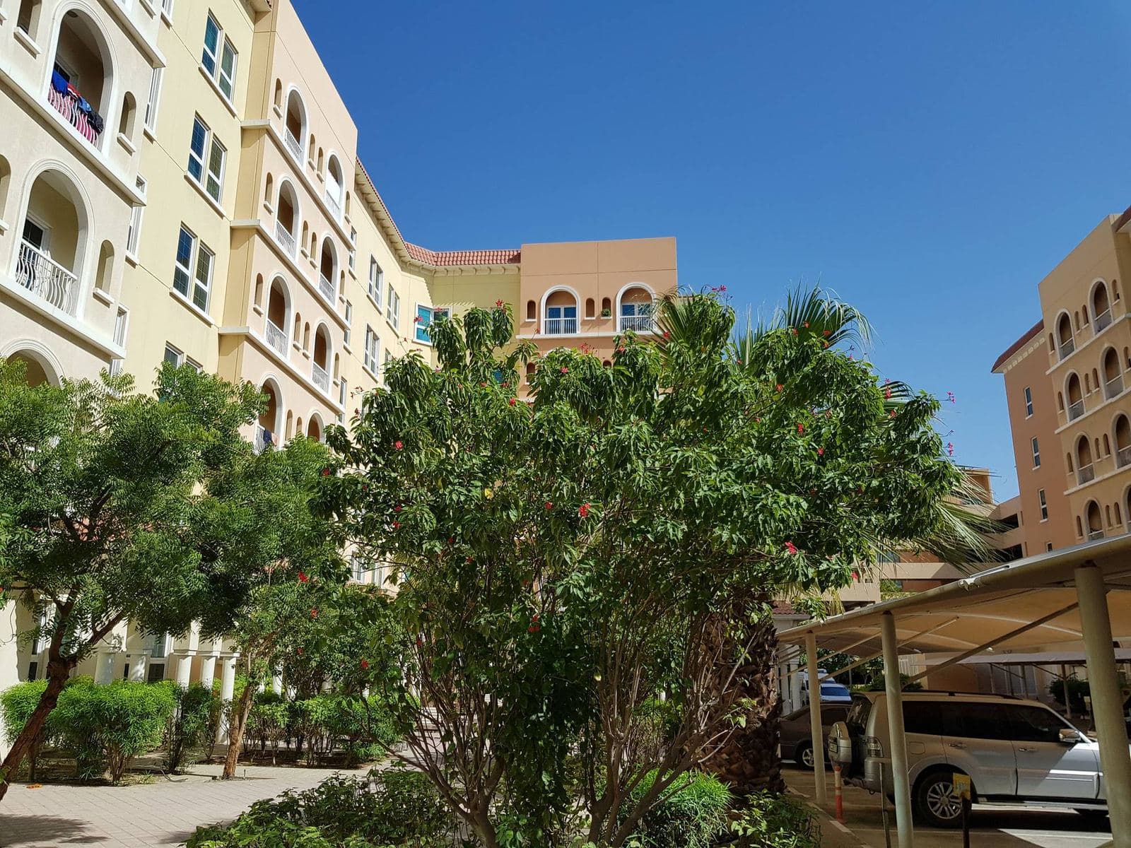 Mediterranean style apartment buildings and green landscaping in Dubai Investments Park