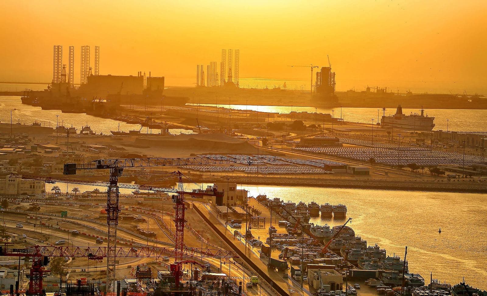 Sunset over the port area with the Dubai Maritime City peninsula and Drydocks World rigs on the horizon