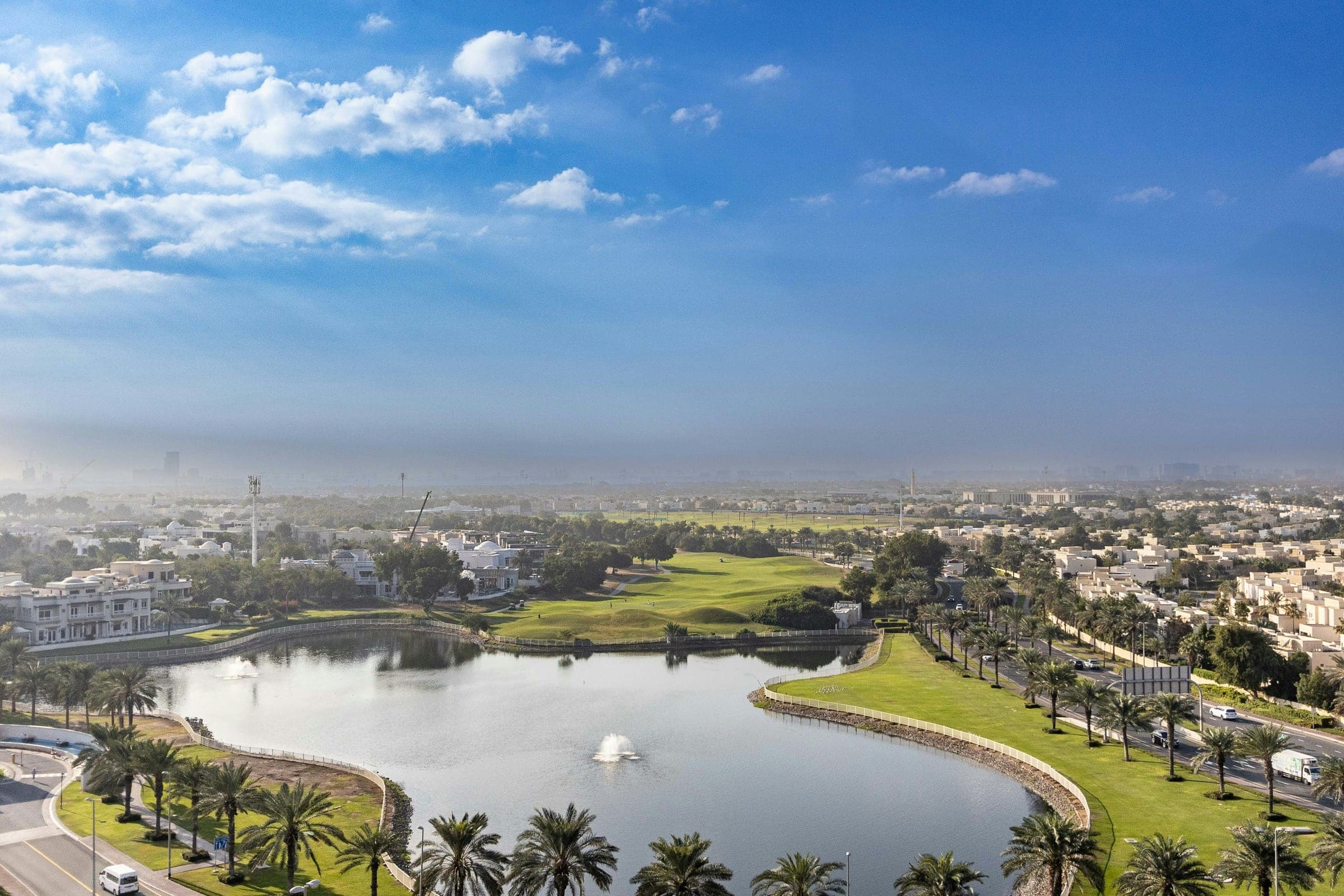 Lake, fountains and golf fairways lined by grand villas in Emirates Hills, Dubai