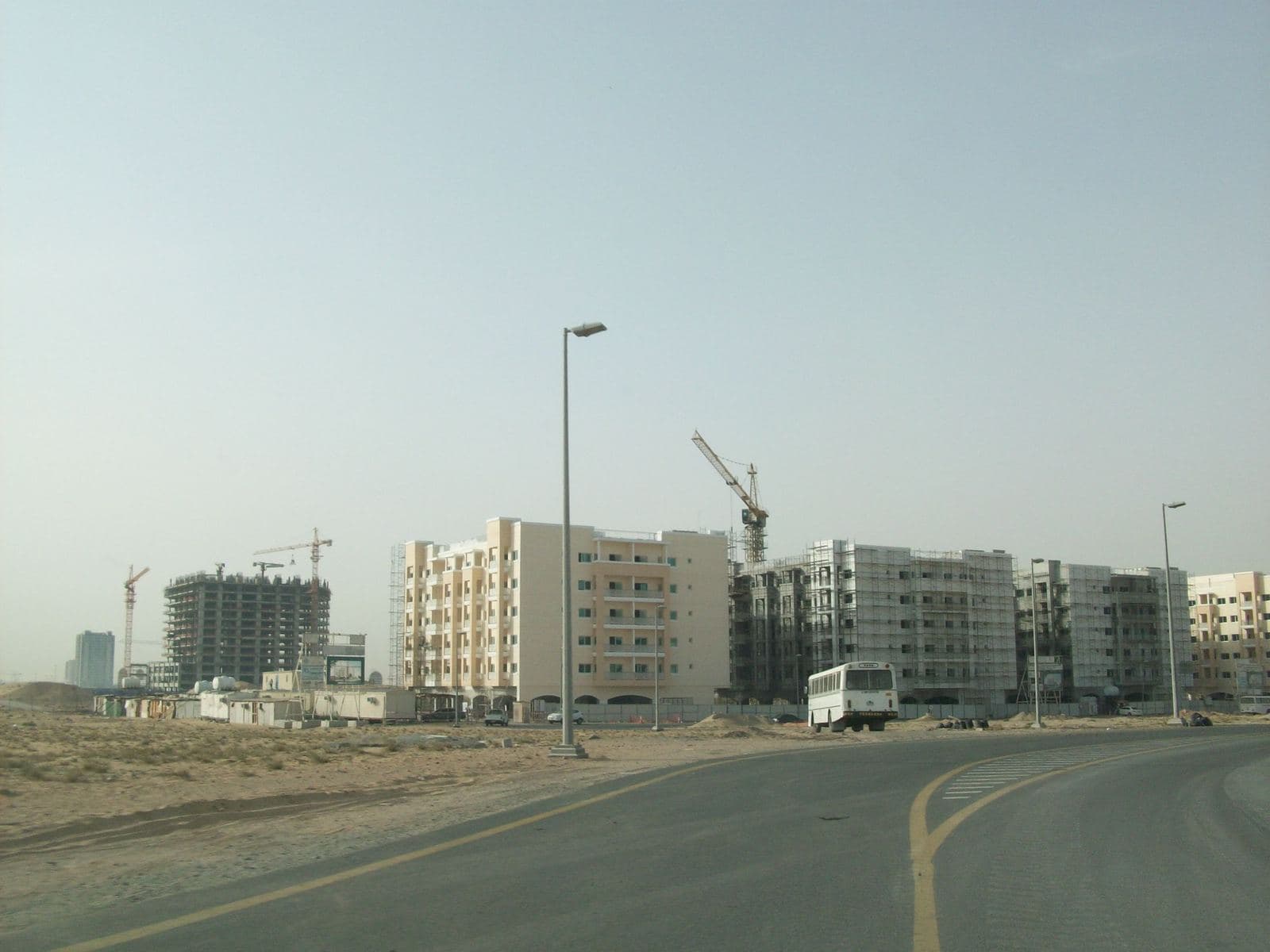 Newly built Queue Point apartment buildings along a road in Liwan, Dubailand