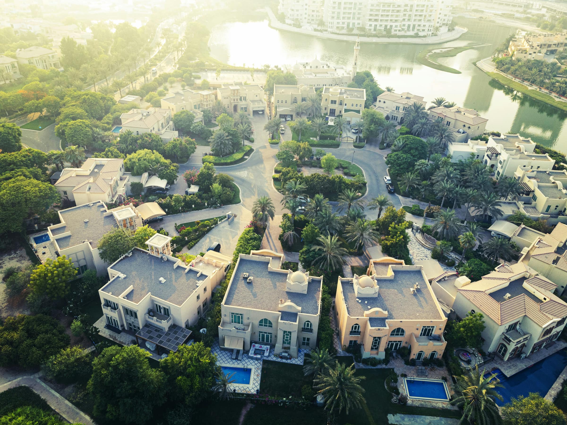 Aerial view of villas, a lakeside mosque and a lake in The Lakes, Emirates Living