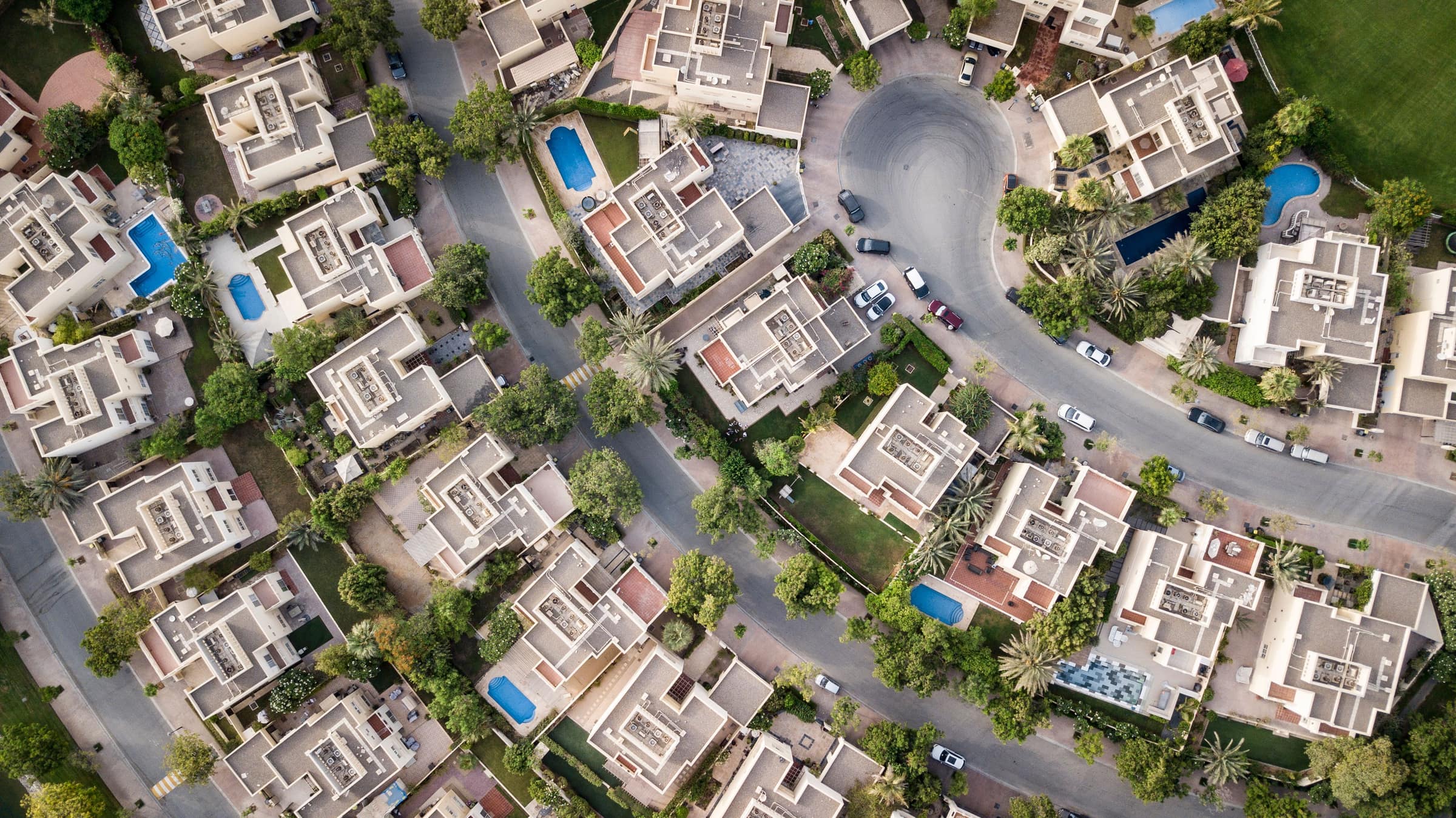 Aerial view of a leafy Dubai villa neighbourhood with private pools