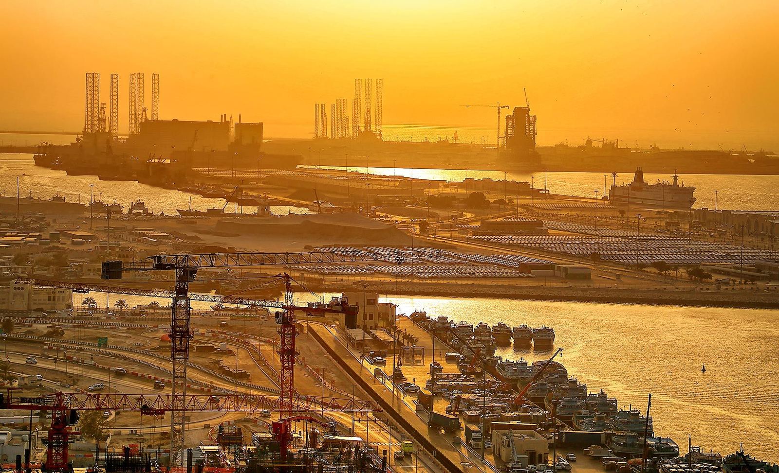 Sunset over the port area with the Dubai Maritime City peninsula and Drydocks World rigs on the horizon