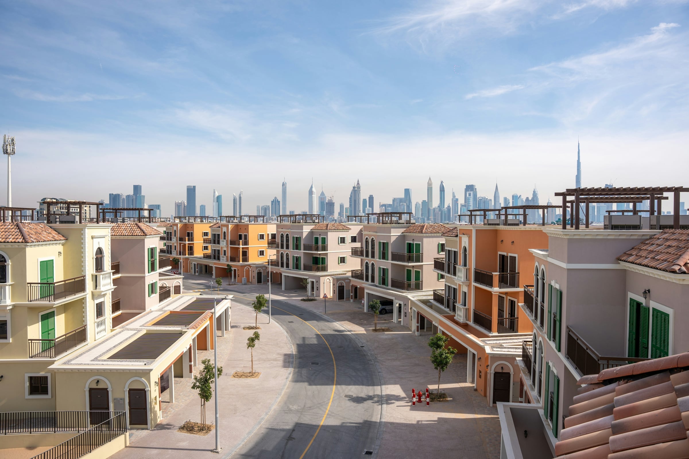 Mediterranean style townhouses and pastel facades of Port de La Mer, with the Downtown Dubai skyline beyond