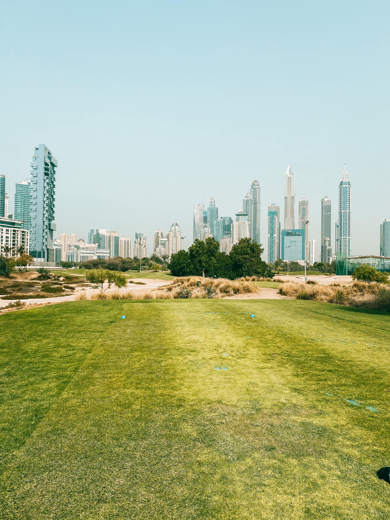 Emirates Golf Club fairway, the green outlook of The Views, with the Dubai Marina skyline